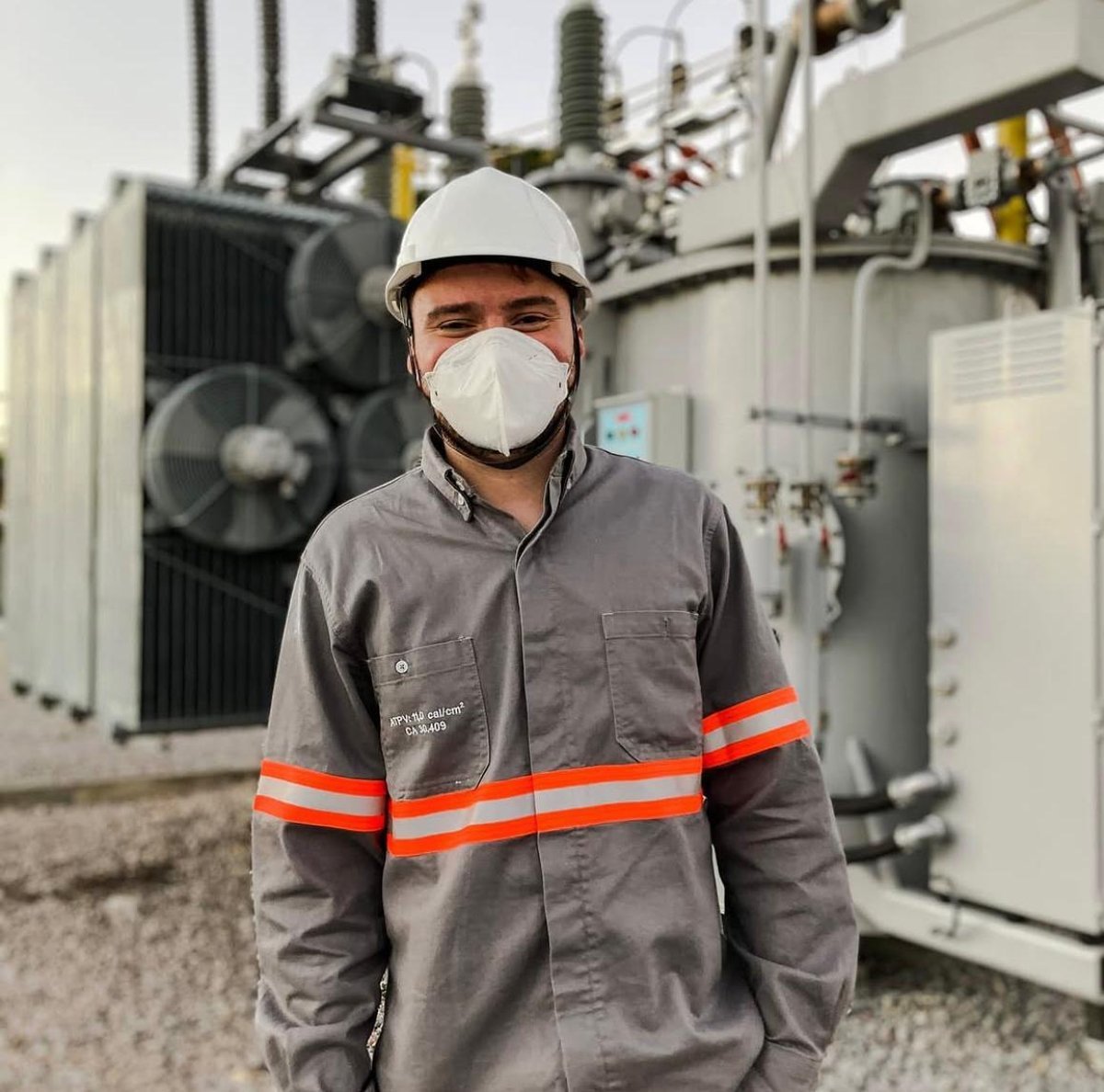 Engenheiro da Lumétria em campo, ao lado de transformador de potência