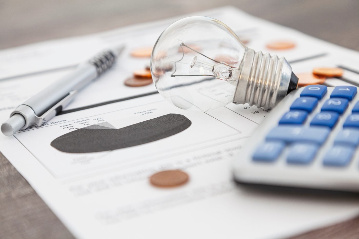Fatura de energia sobre a mesa com calculadora e lâmpada