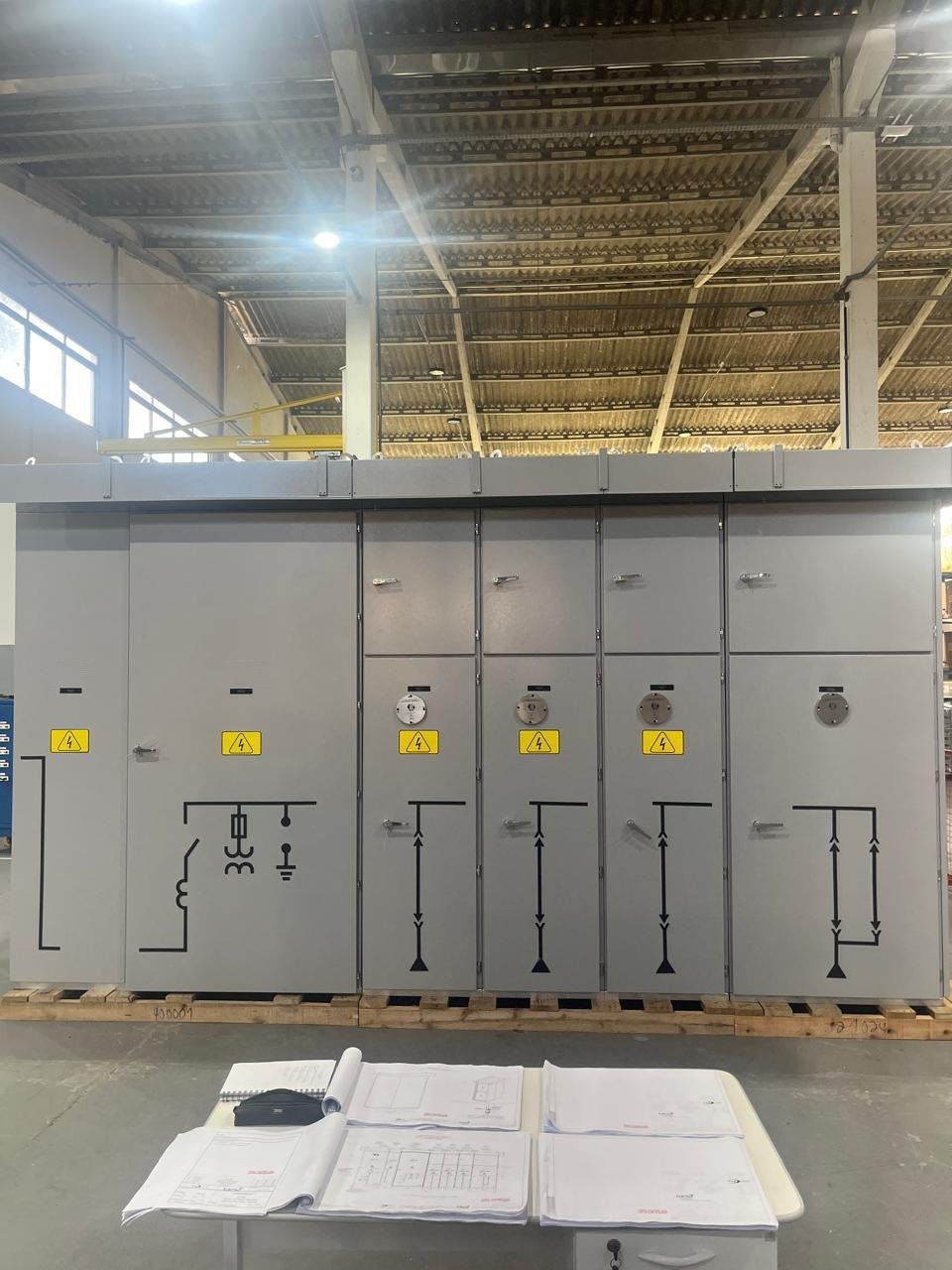 Cabine de entrada e medição em fabricação, com projetos técnicos sobre a bancada