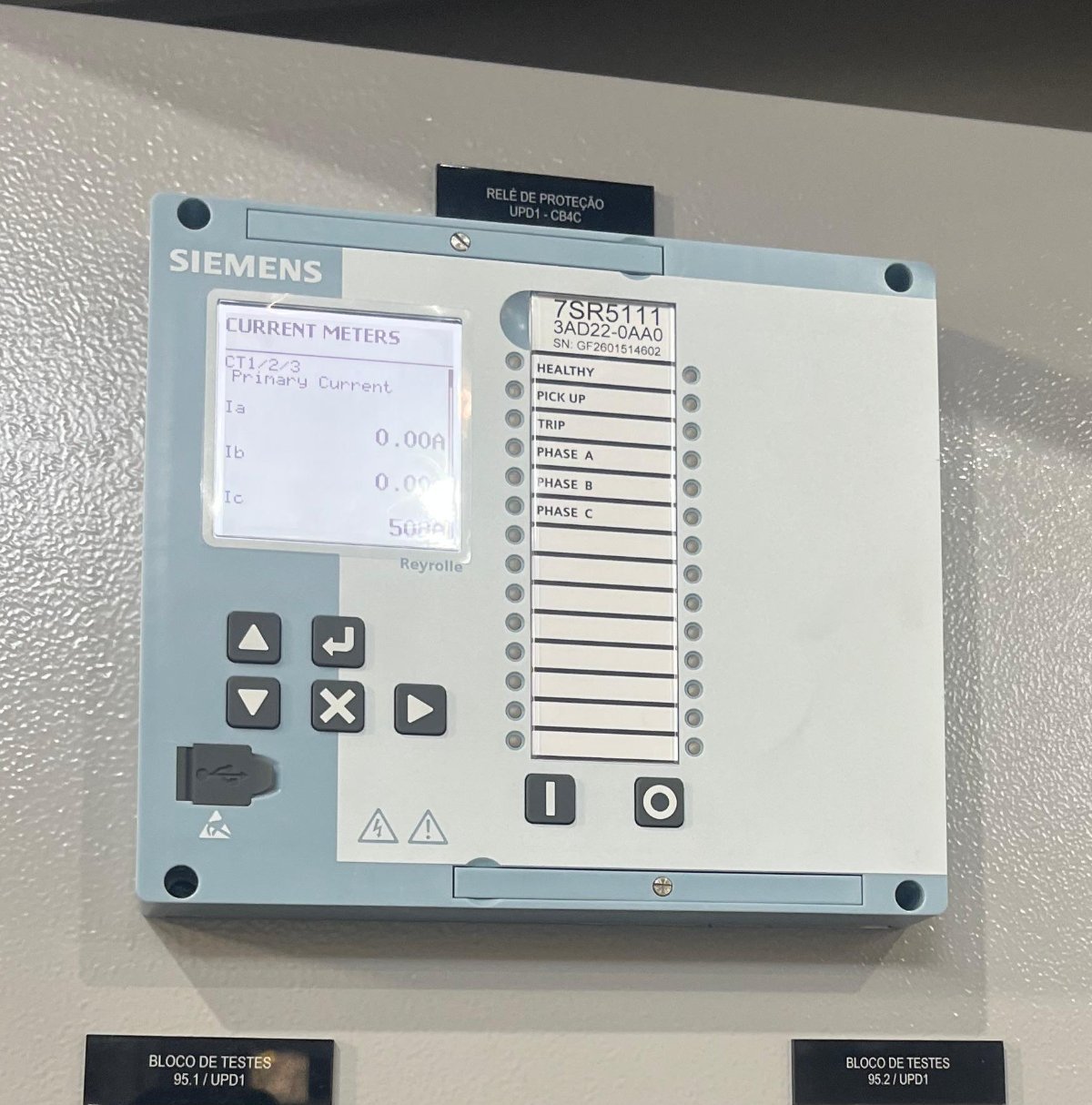 Relé de proteção digital instalado em painel com blocos de testes